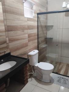 uma casa de banho com um WC, um lavatório e um chuveiro em Suites Jatiuca em Maceió
