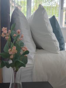 eine weiße Couch mit Kissen und eine Vase mit Blumen in der Unterkunft Modern 1 & 2 Bed Apartments, Desborough, Kettering, Sleeps 3, Free Parking, WIFI, Ideal for Families & Relocations in Kettering + 22 Fotos