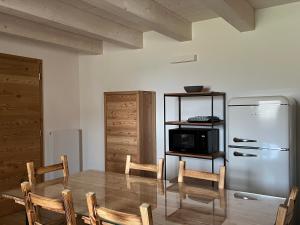 a kitchen with a table and a refrigerator at Camelot Luxury Houses Horses in Pellizzano