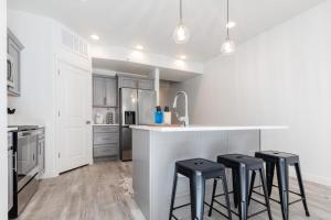 a kitchen with a white counter and stools in it at Bear Lake Fun Close to lake Electric Scooters in Garden City