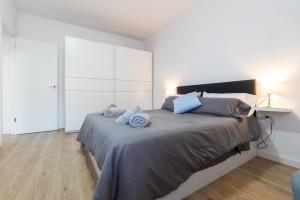 um quarto com uma cama grande e almofadas azuis em Apartment Granollers Up Live II em Granollers