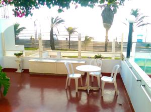 balcón con mesa, sillas y bañera en Hostal La Rivera en Huanchaco