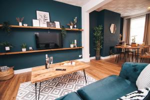 sala de estar con paredes azules y mesa de madera en Commercial House, By Solace Stays, en Newport