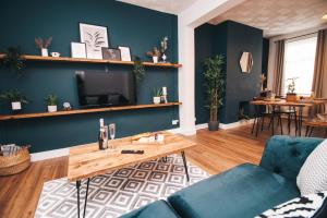 a living room with blue walls and a wooden table at Commercial House, By Solace Stays in Newport