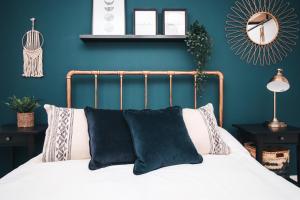 紐波特的住宿－Commercial House, By Solace Stays，一间卧室拥有蓝色的墙壁,配有一张带黑色枕头的床。