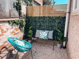 un banco y una silla en un patio con plantas en Commercial House, By Solace Stays en Newport
