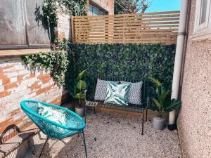 a bench and a chair in a courtyard with plants at Commercial House, By Solace Stays in Newport