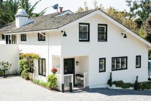 een wit huis met zwarte luiken bij Hotel Carmel in Carmel