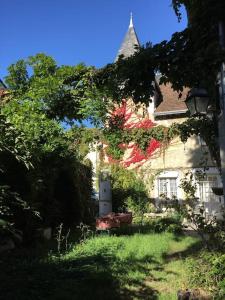 uma casa velha com um banco no quintal em La Volière em Champigny-sur-Veude
