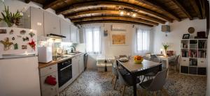 uma cozinha com armários brancos, uma mesa e uma sala de jantar em Calle Seminario ChioggiaPL em Chioggia