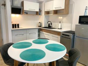 a kitchen with a table and chairs in a kitchen at Baltic Sea Flair: Just steps from the sea in Dziwnów +11 photos