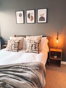 een slaapkamer met een groot bed met kussens erop bij Grosvenor House by Solace Stays in Newport