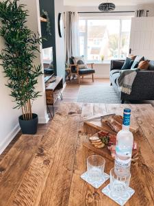 a bottle of water and two glasses on a table in a living room at Grosvenor House by Solace Stays in Newport