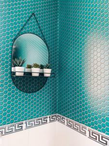 a bathroom with a blue tiled wall with a mirror at Grosvenor House by Solace Stays in Newport