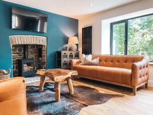 a living room with a couch and a fireplace at Falls Cottage by Solace Stays in Merthyr Tydfil