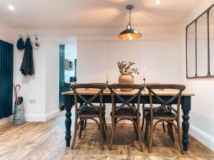 jadalnia z drewnianym stołem i krzesłami w obiekcie Falls Cottage by Solace Stays w mieście Merthyr Tydfil