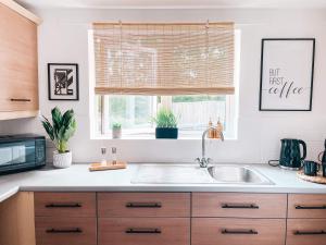 a kitchen with a sink and a window at Hollybush Apartment, by Solace Stays in Newport