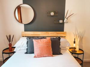 Dormitorio con cama con espejo y almohadas en Hollybush Apartment, by Solace Stays en Newport