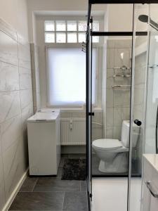 a white bathroom with a toilet and a window at Elsasser Haus - 2 Zimmer, 3 Betten, 5 Personen, kontaktloses Einchecken, Netflix in Wuppertal