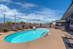 a swimming pool on a patio with chairs around it at Best Western Athens Inn in Athens