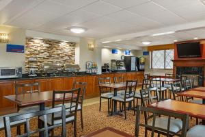 a restaurant with wooden tables and chairs and a bar at Best Western Plus The Inn at Sharon/Foxboro in Sharon