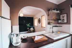 cocina con encimera con fregadero y espejo en Partridge Apartment by Solace Stays, en Cardiff