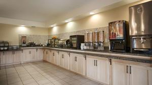 a large kitchen with white cabinets and a counter top at Best Western Plus Woodstock Hotel Conference Centre in Woodstock