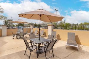 a table and chairs with an umbrella on a patio at Best Western Plus The Charles Hotel in St. Charles