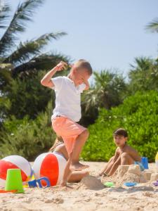 a young boy playing in the sand on the beach at Paradisus Cancun All Inclusive in Cancún