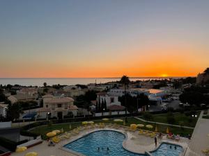 vista para um resort com piscina e pôr-do-sol em Palmeira Gale em Albufeira