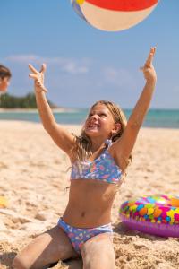 une petite fille en maillot de bain jouant avec un ballon de plage dans l'établissement Paradisus Cancun All Inclusive, à Cancún