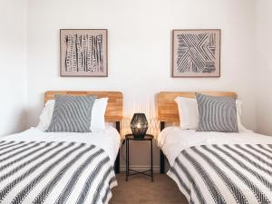 two beds sitting next to each other in a room at St Curigs House, by Solace Stays in Christchurch