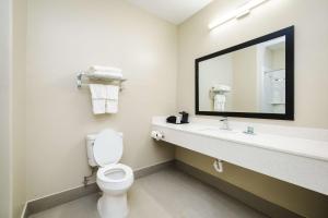 un bagno con un water, un lavandino e uno specchio di SureStay Studio by Best Western Conroe Downtown a Conroe