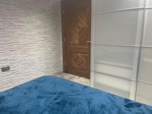 a bedroom with a wooden door and a blue bed at Luxury Small 1 bed property West London in Perivale