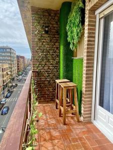 um banco de madeira sentado na varanda de um edifício em magnífica y moderna vivienda em Caravaca de la Cruz