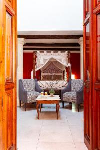 ein Bett mit 2 Stühlen und einem Tisch in einem Zimmer in der Unterkunft Viva Merida Hotel Boutique in Mérida