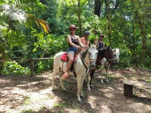 a group of people riding horses in the woods at Hacienda Mil Bellezas in Quepos