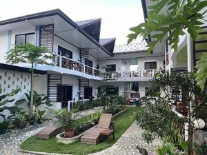 a courtyard of a building with chairs and trees at Hotel Oasis Port Barton in San Vicente