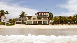 a house on the beach near the water at Cormorant Beach House in Puerto Villamil