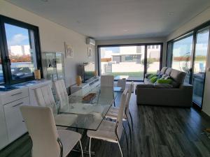 een woonkamer met een glazen tafel en stoelen bij Villa Joia in Bombarral