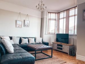 a living room with a couch and a tv at Ty-Fry House, by Solace Stays in Cardiff