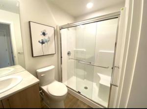 a bathroom with a shower and a toilet and a sink at Perfect Brand New Condo Downtown Sidney in Sidney