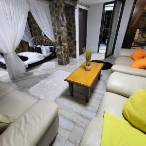 una sala de estar con sofás blancos y una mesa de madera. en Cabana Ana en Petroşani