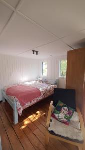 een slaapkamer met een bed en een stoel in een kamer bij Limayko Patagonia in Cochrane