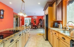 a kitchen with orange walls and a dining room at Villa Verde B&B, bsm, Greenwood Lake, NY in Monroe