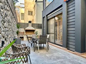 un patio avec une table et des chaises et un bâtiment dans l'établissement T&T - Luxury apartments, à Athènes