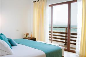 a bedroom with a bed with a view of the ocean at Cormorant Beach House in Puerto Villamil