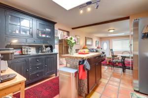 una cocina con armarios de madera oscura y una mesa en Charming Santa Fe Vacation Rental - Near Casino, en Pojoaque