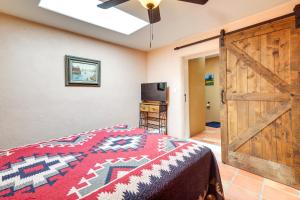 1 dormitorio con cama y puerta corredera de granero en Charming Santa Fe Vacation Rental - Near Casino, en Pojoaque