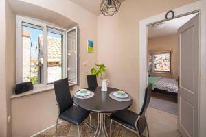 a dining room with a table and chairs and a bedroom at Maro Skyline in Dubrovnik